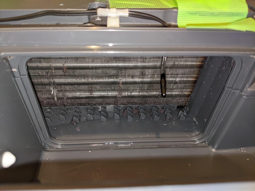 清掃後の同じドラム式洗濯機のヒートポンプ。付着したホコリが除去され、熱交換器の金属フィンが見える状態。